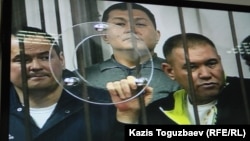 Группа фигурантов «Хоргосского дела» слушает свой приговор. Фото с монитора в комнате для журналистов. Алматы, 12 апреля 2014 года. 