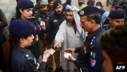 Pakistani police check the documents of Afghan refugees during a search operation to find illegal immigrants on the outskirts of Karachi. (file photo)