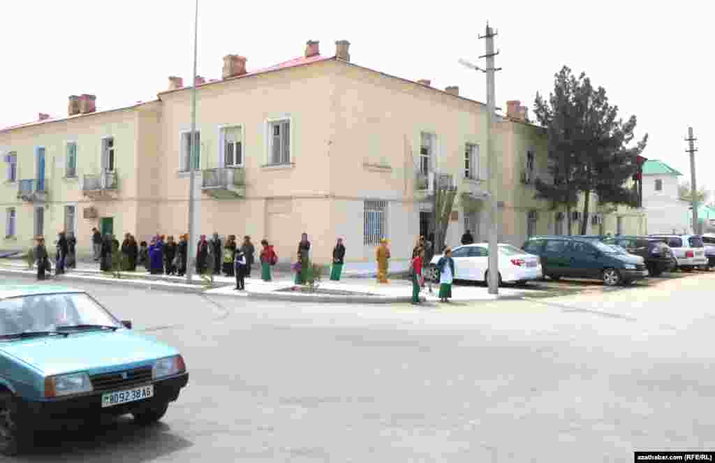 Graždan köçesiniň ugrunda awtobusa garaşyp duran ýolagçylar