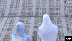 زنان بازمانده از فجایع شهر سربرنیتسا در بوسنی و هرزه گوین در حال جستجوی نام بستگان خود که توسط نیروهای صرب بوسنی به رهبری رادوان کارادجیچ کشته شدند.(عکس: AFP)