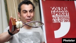 Автор премии Арман Давтян демонстрирует премию «Да будет свет»