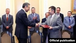 Armenia - Arman Khachaturian (R), head of the National Competitiveness Foundation and Andre Andonian of McKinsey & Company sign an agreement in Yerevan, 18Jul2013.