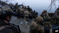 Ukrainian soldiers board a boat on the shore of the Dnieper River at the front line near Kherson, Ukraine, on October 15. The Ukrainian military has been seeking to establish several bridgeheads on the east bank in recent weeks. 