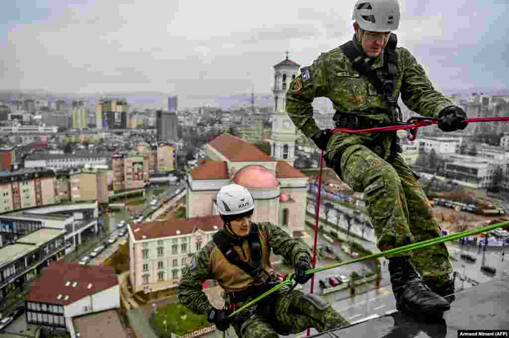 Косовские солдаты вешают гигантский флаг, чтобы поблагодарить медработников за борьбу с пандемией COVID-19. (AFP/Арменд Нимани)