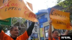 Журналистер Рысбек Сәрсенбайұлы мен Сергей Дуванов қолдарына "Бүгін - Жовтис, ертең - Сіз!" деп екі тілде жазылған плакаттарды алып барады. Алматы, 23 қыркүйек 2009 жыл.  