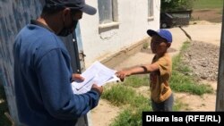 Почтальон в селе Амангельды в Туркестанской области доставляет домашние задания школьникам, обучающимся дистанционно, апрель 2020 года.