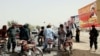 Afghan security officials check people on a roadside in Helmand as security has been intensified ahead of the upcoming parliamentary elections.