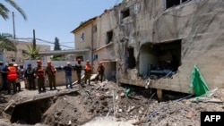 Israeli soldiers and first responders check the damage caused to a building from an Iranian strike in Beit She'an on June 21, 2025. (Photo by Jalaa Marey / AFP)