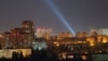 Ukrainian service personnel use searchlights to look for drones in the sky over the city center during a Russian drone strike in Kyiv on September 9.