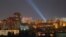 Ukrainian service personnel use searchlights to look for drones in the sky over the city center during a Russian drone strike in Kyiv on September 9.
