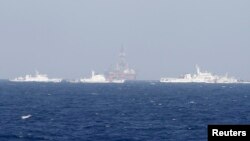 Кытайдын Түштүк - Кытай деңизинде, Вьетнамдын  жээгинен 210 чакырым гана алыстыкта жайгашкан мунай бургулоочу жабдуусун кемелер  кайтарып турат. 14-май, 2014-жыл. 