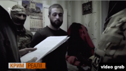 Seyran Saliyev apiske alınğan vaqıtta. Rusiye FSB-sınıñ videosından skrinşot. 2017 senesi