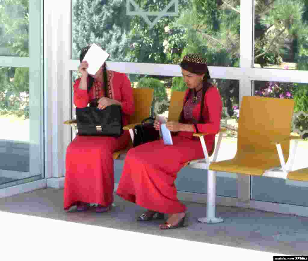 Abituriýent gyzlar durlgada awtobusa garaşýarlar