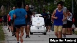 Робат на вуліцы ў Сынгапуры нагадвае бегунам аб захоўваньні бясьпечнай адлегласьці падчас пандэміі