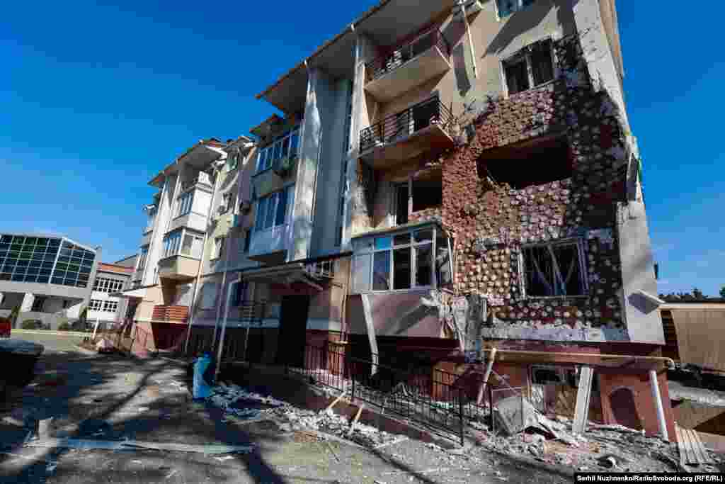 У адным з раёнаў Ірпяня пашкоджаны жылы дом. Адны дамы рамантуюць практычна з нуля, а ў іншых, як на фота, за тры гады аднавілі толькі пашкоджаны фасад.Зьлева фота 11 сакавіка 2022 году, справа — з сакавіка 2025 году