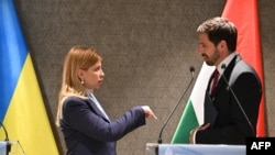 Віце-прем'єр-міністр України Ольга Стефанішина (ліворуч) розмовляє з Левенте Мадяром, Державним секретарем Міністерства закордонних справ і торгівлі Угорщини, після виступу на прес-конференції в Будапешті, Угорщина, 29 квітня 2025 року