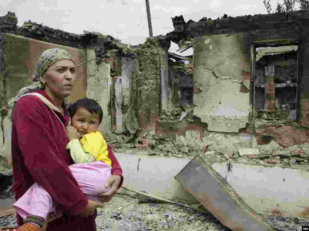 Ошанка с ребенком на пепелище родного очага, июнь, 2010.