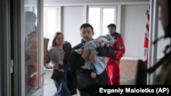 Аткылоодон чарчап калган 1,8 айлык наристени ооруканага жеткиришүүдө. Мариуполь.  4-март,  2022-жыл
