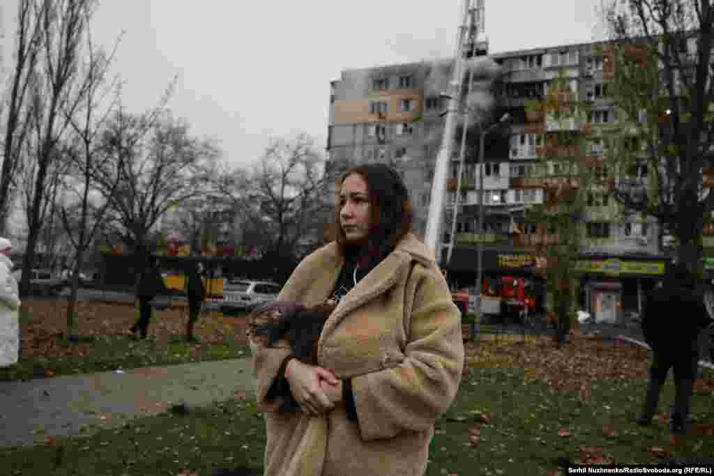 У Дарницькому районі Києва влучання сталося в багатоповерховий будинок. На фото: мешканці будинку чекають, доки працівники ДСНС загасять пожежу, що розгорілася внаслідок російського удару. Київ, 29 листопада 2025 року