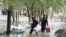 Afghan men carry their belongings as they evacuate from their residential area after flash flooding in the west of Kabul on April 16. 