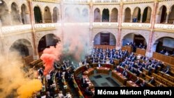 Членове на опозиционната партия „Моментум“ запалиха димки в унгарския парламент при гласуването на законопроект, който забранява провеждането на ЛГБТ прайдовете, Будапеща, Унгария, 18 март 2025 г. 