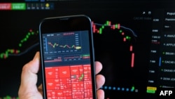 На цій фотографії, зробленій 7 квітня 2025 року, показано біржові графіки та індекси, що відображаються на смартфоні в Брюсселі, коли трейдери відреагували на масштабні тарифи президента США.