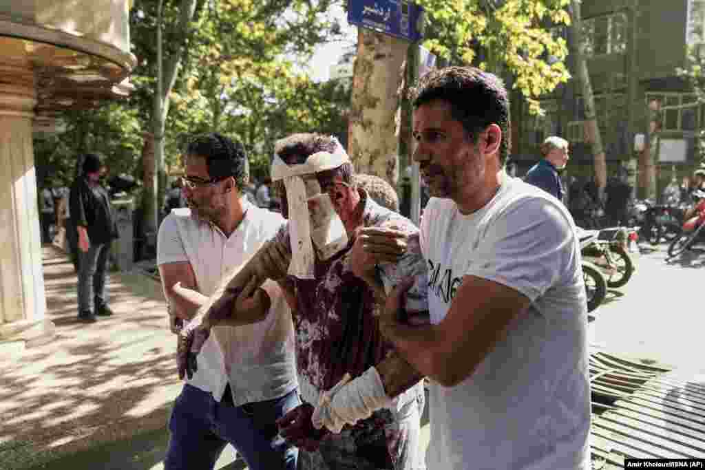 Параненага мужчыну выносяць зь месца выбуху ў цэнтры Тэгерану, 15 чэрвеня 2025 году.