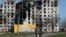Local residents walk past a destroyed apartment building in Mariupol on April 20. 