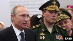 Начальник Генштабу Збройних сил Росії, заступник міністра оборони Росії, генерал армії Валерій Герасимов (в центрі) з президентом Росії Володимиром Путіним (ліворуч). 16 червня 2015 року