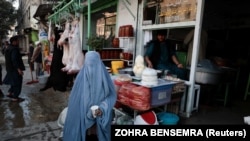 Афганка со стаканом молока, который ей бесплатно дал продавец на рынке в Кабуле
