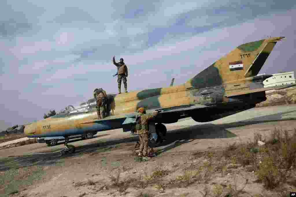 شورشیان بر روی یک هواپیمای جنگی متعلق به نیروی هوایی سوریه در فرودگاه نظامی حماه در تاریخ ۱۶ آذر ۱۴۰۳ دیده می&zwnj;شوند.