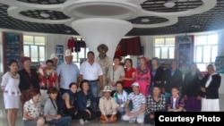 Кыргызстандык саякатчы илимпоздор жана студенттер кытайлык кыргыздардын тобу менен КЭРдин Кызыл-Суу Кыргыз автоном облусуна караштуу Ак-Чий ооданындагы Кара-Булак айылындагы Жусуп Мамайдын музейинде маркум манасчынын момдон жасалган айкелинин жанында. 30.7.2015.