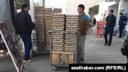 Türkmenistanyň dükanlarynyň biriniň öňünde işgärler ýumurtgalary dükana daşaýarlar. (Illýustrasiýa suraty)