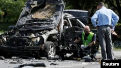 Слідчі працюють на місці вибуху автомобіля, в якому загинув полковник Максим Шаповал. Київ, 27 червня 2017 року