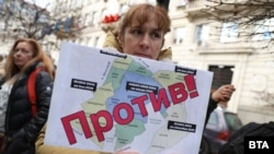 Протестираща пред Столичната община държи принтирана карта на планираното догодина разширено зонално паркиране в София, 20 ноември 2025 г.