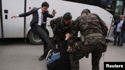 یوسف یرکل درحال لگد زدن به معترضی که پلیس او را روی زمین انداخته است