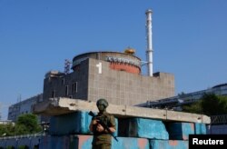 Российский военнослужащий стоит на страже на блокпосту возле Запорожской АЭС перед прибытием миссии экспертов МАГАТЭ, 15 июня 2023 года