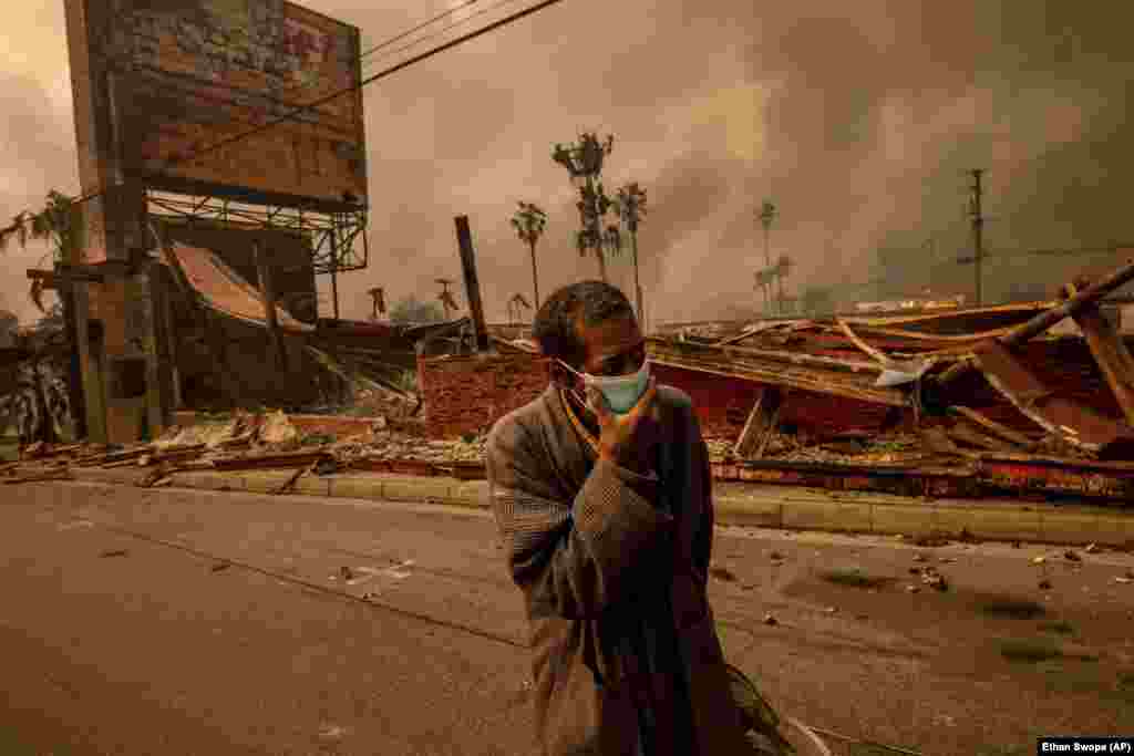 Чоловік іде повз зруйноване вогнем підприємство у Альтадені &nbsp;