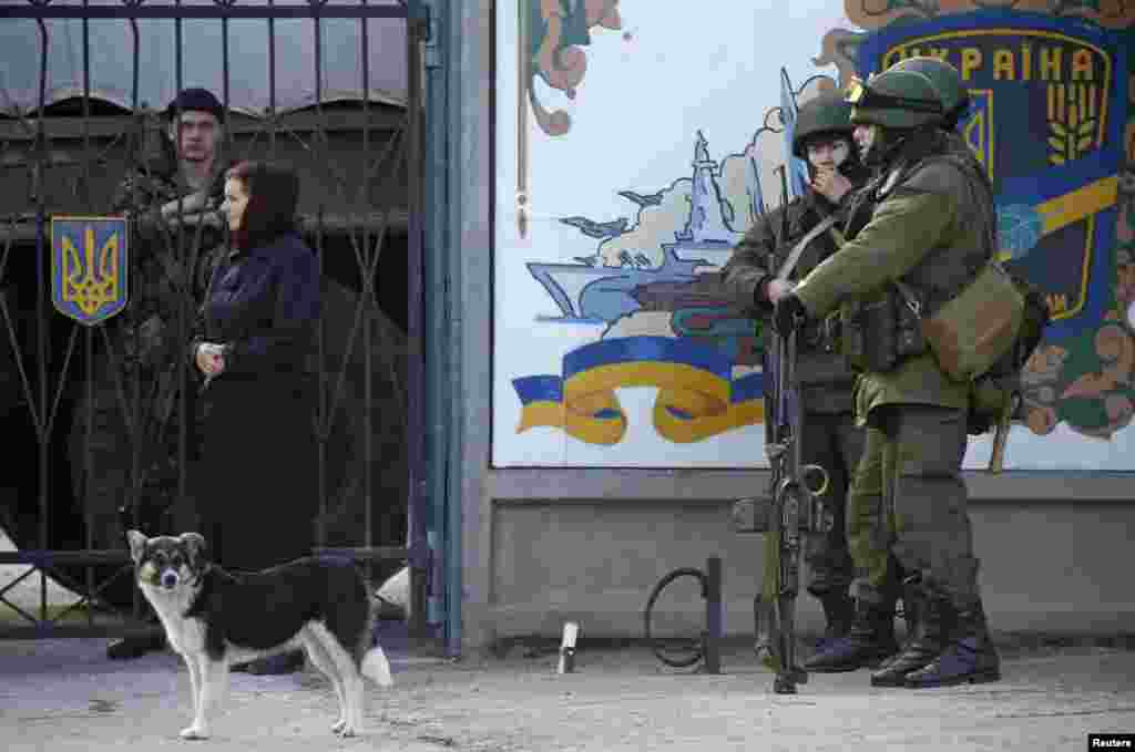 Военные рядом с КПП украинской военной базы. За забором видны украинские военнослужащие.&nbsp;