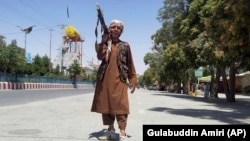 A Taliban fighter poses for a photo as he patrols in the city of Ghazni.
