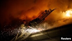 Өрт өчүрүүчүлөр орус армиясынын аткылоосунан кийин тутанган тилсиз жоо менен күрөшүп жатышат. 5-август, 2023-жыл. Донецк. Иллюстрациялык сүрөт. 