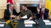 U.K. Prime Minister Keir Starmer (left) and Defense Secretary John Healey (right) applaud Ukrainian President Volodymyr Zelenskiy (center) after he addressed an extraordinary meeting of the British Cabinet on July 19. 