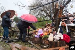 Людзі кладуць кветкі і цацкі да руінаў дома, у якім ад расейскага ўраду загінеулі трое дзяцей. Каростышаў Жытомірскай вобласьці, 25 траўня 2025