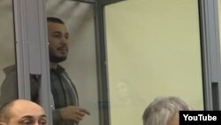 Akbarali Abdullaev speaks inside the defendant's cage as he attends a court hearing in Kyiv in February.