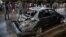 People look at a damaged vehicle after a deadly suicide bomb attack in Kabul on November 16.