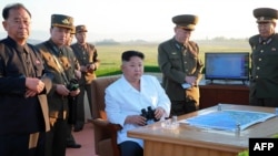 کیم جونگ‌اون در وسط تصویر؛ شمار آزمایش‌های موشکی و نیز توانایی و برد این جنگ‌افزارها با روی کار آمدن او افزایش پیدا کرده‌است