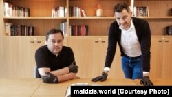 Павал Мацукевіч і Рыгор Астапеня з кнігай «Вялікае майстэрства артылерыі, частка першая» («Artis Magnae Artilleriae pars prima») Казімера Семяновіча