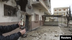 یک شهروند سوری بازمانده خمپاره های پرتاب شده به سور شهر حمص از سوی ارتش سوریه را نشان می دهد.
