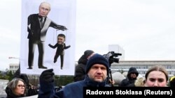 Плакат із зображенням керівника РФ Володимира Путіна (ліворуч) і прем’єр-міністра Словаччини Роберта Фіцо (праворуч) на мітингу протесту в Братиславі, 23 грудня 2024 року