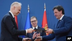 Președintele sârb Aleksandar Vucic (centru) urmărește cum miniștrii Apărării maghiar (b) și sârb fac schimb de documentul acordului de cooperare militară dintre cele două țări. 1 aprilie 2025